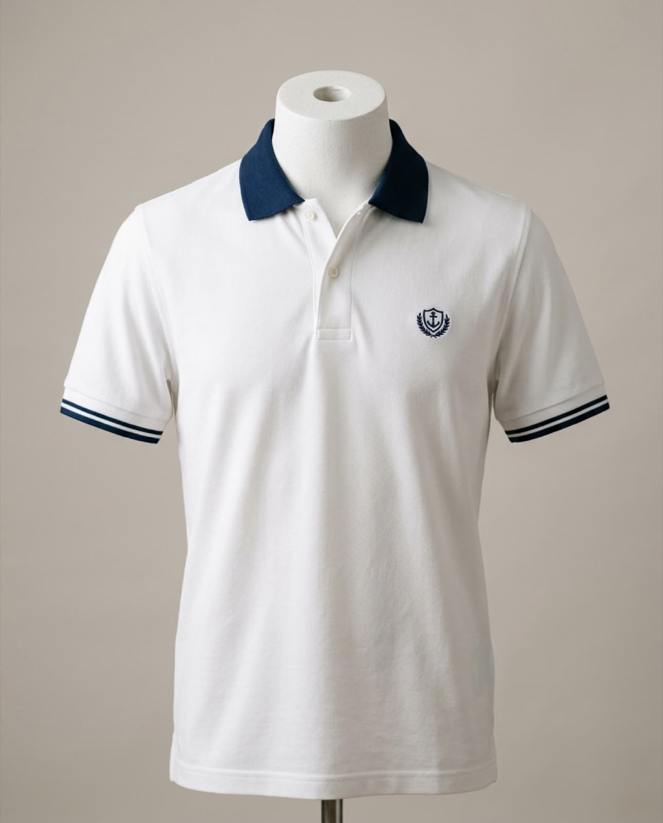Polo piqué blanco con cuello azul en contraste y emblema bordado (imagen ilustrativa)